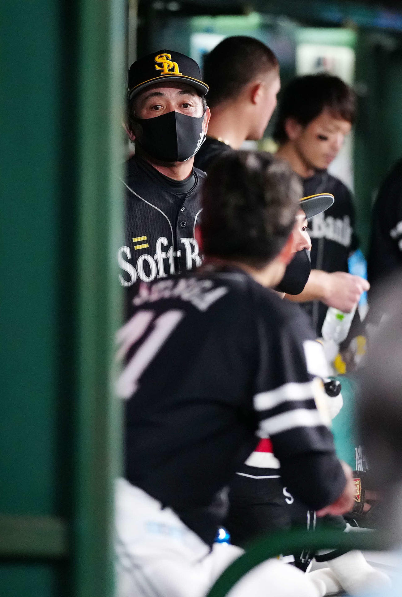 西武対ソフトバンク　7回裏終了後、ベンチでソフトバンク先発の千賀（手前）に言葉をかける工藤監督（撮影・江口和貴）