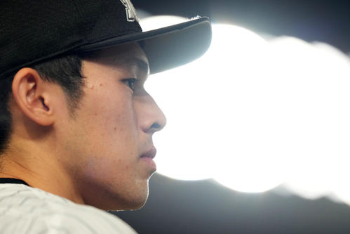 ロッテ対楽天　7回裏途中、キャッチボールの最中にスコアを見つめるロッテ佐々木朗（撮影・横山健太）