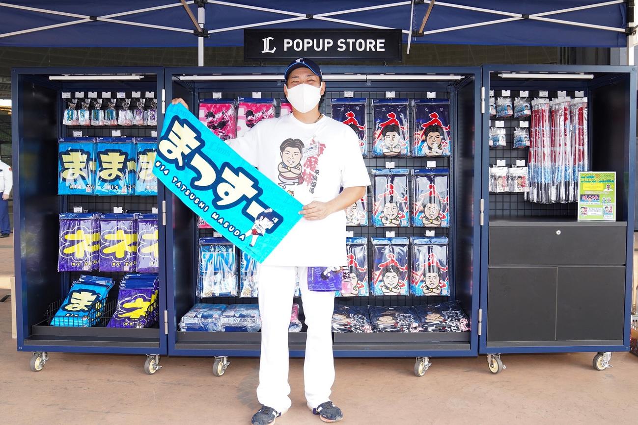 一日店長を務めた西武高橋アカデミーコーチは自身がプロデュースしたグッズを手に笑顔（球団提供）