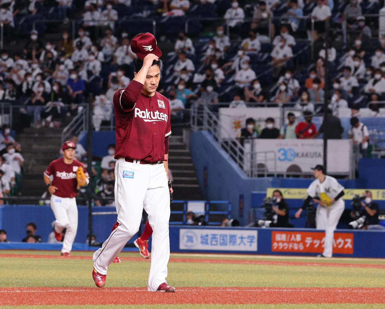ロッテ対楽天　2回裏の登板を終え先制を許した楽天先発の田中将（手前）は渋い表情で引き揚げる（撮影・垰建太）