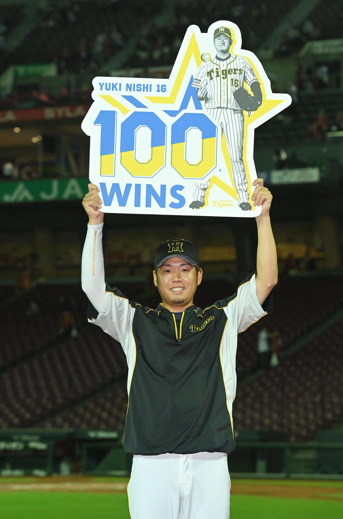 広島対阪神　通算100勝を達成し、笑顔で記念ボードを掲げる阪神西勇