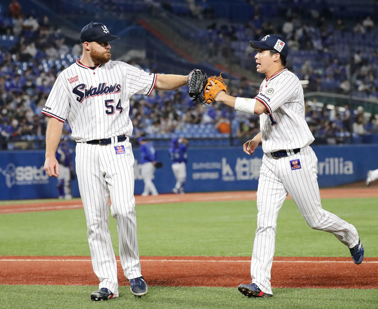 ヤクルト対DeNA 5回表DeNA1死一塁、牧を遊ゴロ併殺に仕留めて山田（右）とグラブタッチするサイスニード（撮影・丹羽敏通）
