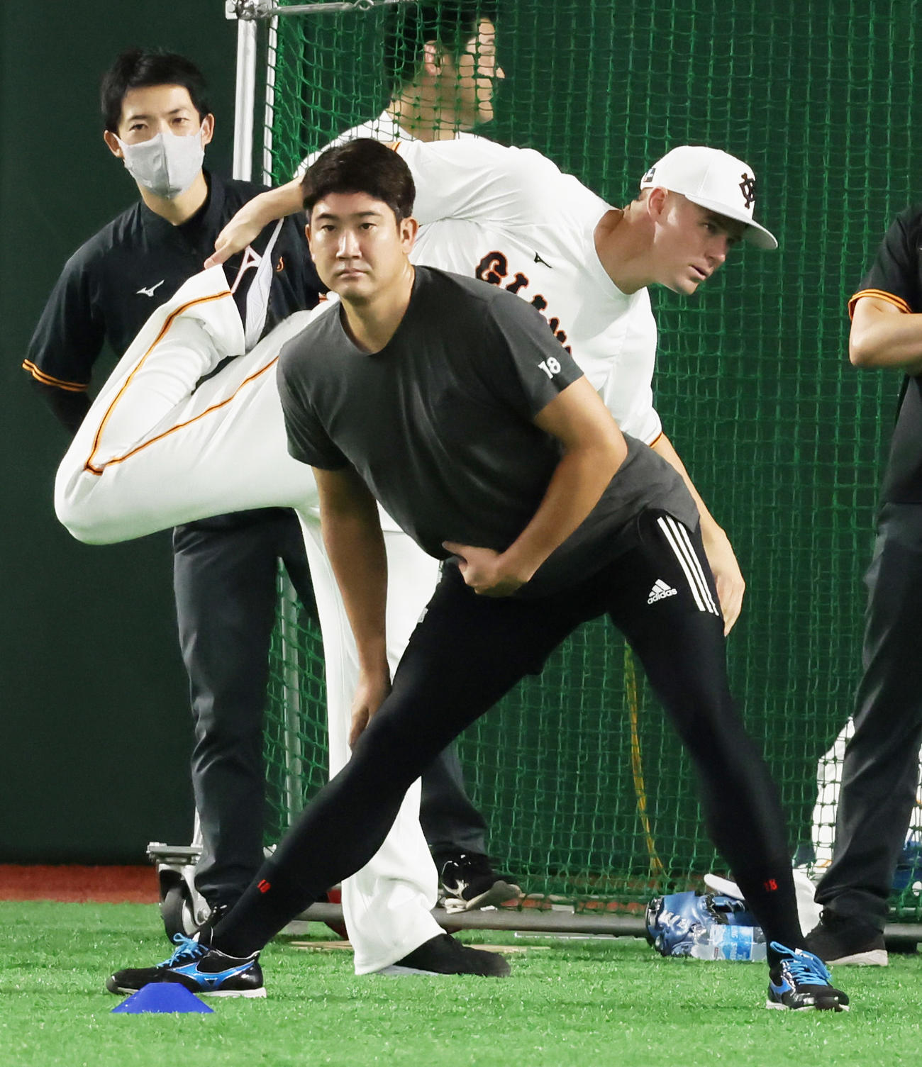 試合前、体を動かす巨人の菅野（手前）とハイネマン（撮影・足立雅史）