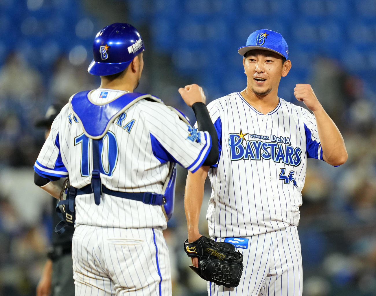 DeNA対阪神　9回表途中から登板したDeNA田中健（右）は、試合を締めて笑顔で捕手戸柱とタッチを交わす（撮影・横山健太）