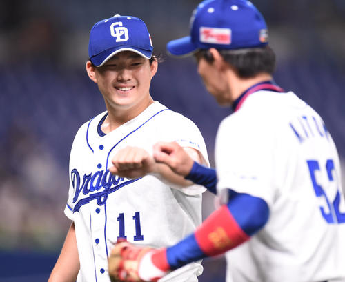 中日対ヤクルト　5回表ヤクルト攻撃終了、加藤翔（右）と笑顔でタッチをかわしベンチへ戻る小笠原（左）（撮影・森本幸一）