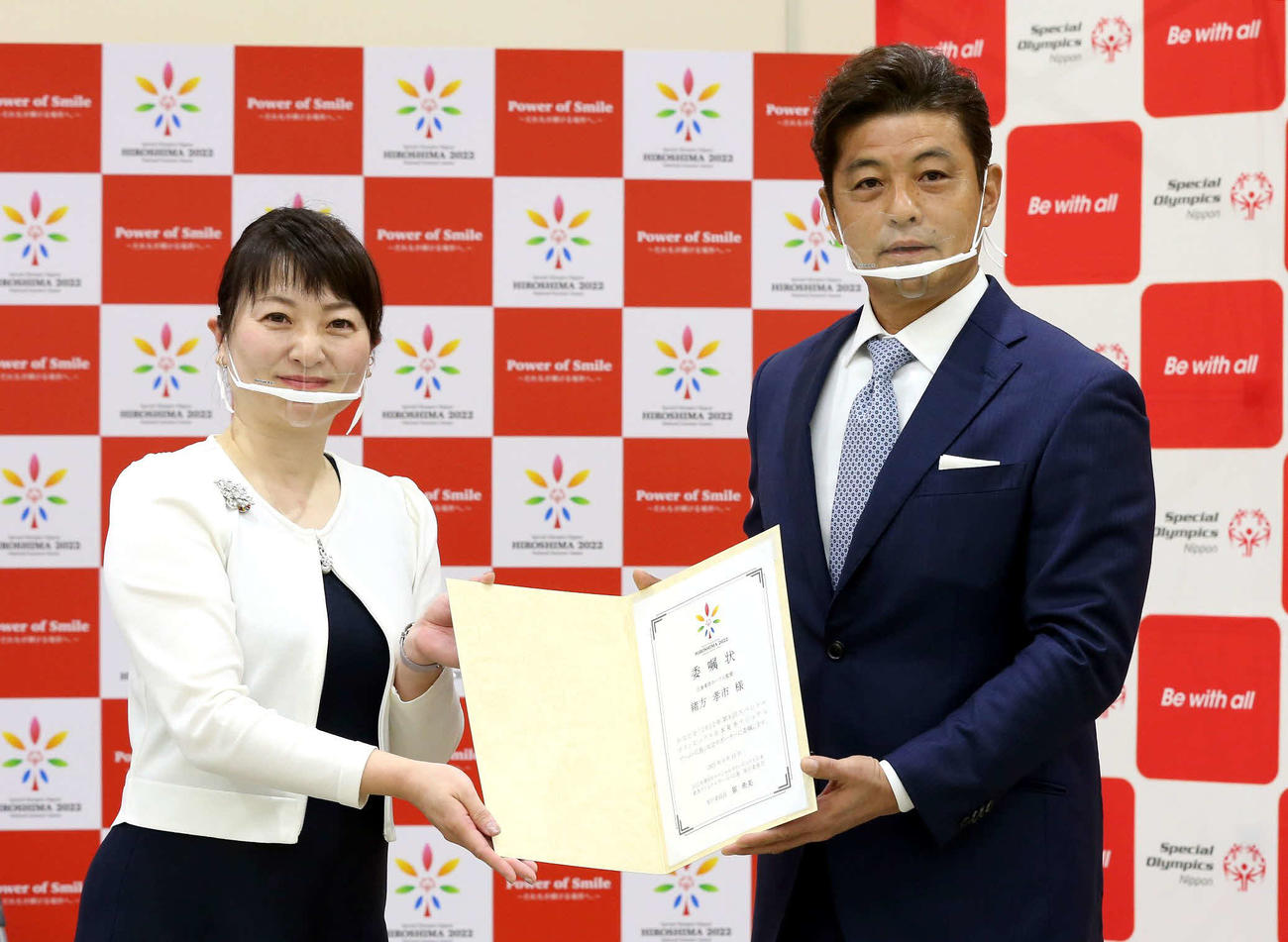 委嘱状を手に写真撮影に応じる緒方氏（右）と崔委員長（代表撮影）