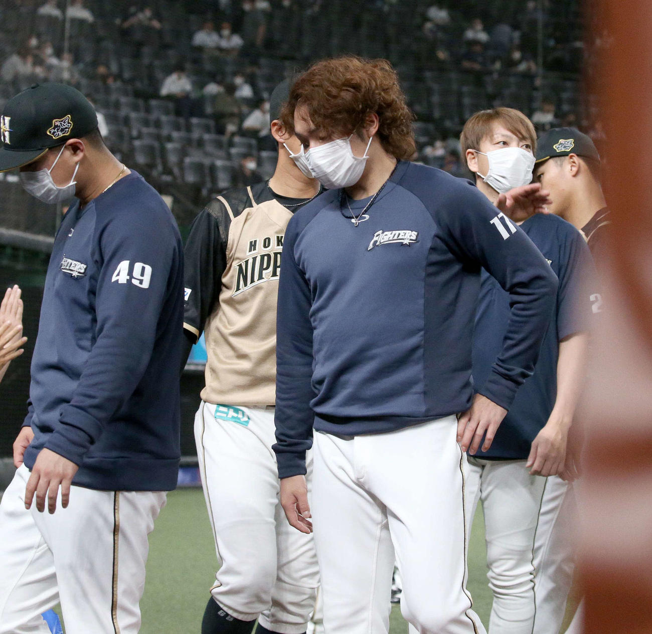 西武対日本ハム　試合後、グラウンドを引き揚げる日本ハム伊藤（中央）（撮影・黒川智章）