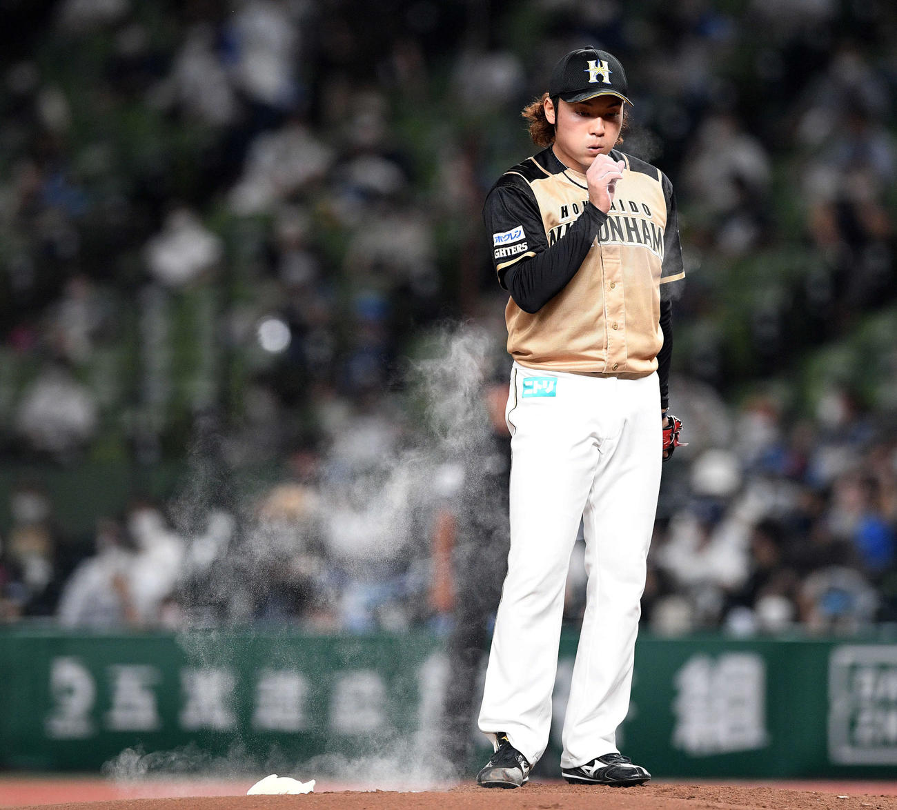 西武対日本ハム　ロジンの粉を吹く日本ハム先発の伊藤（撮影・滝沢徹郎）