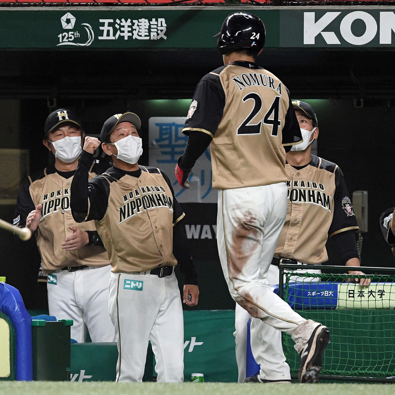 西武対日本ハム　6回表日本ハム1死三塁、王の中犠飛から生還した野村（手前）を迎える栗山監督（左奥から2人目）（撮影・滝沢徹郎）
