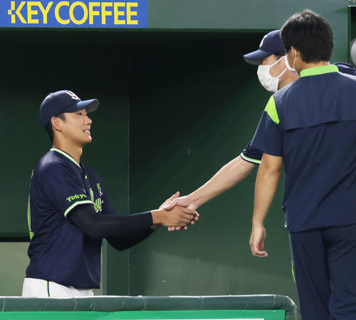 巨人対ヤクルト　7回1失点で勝利を挙げたヤクルト奥川（左）は高津監督と握手を交わす（撮影・足立雅史）