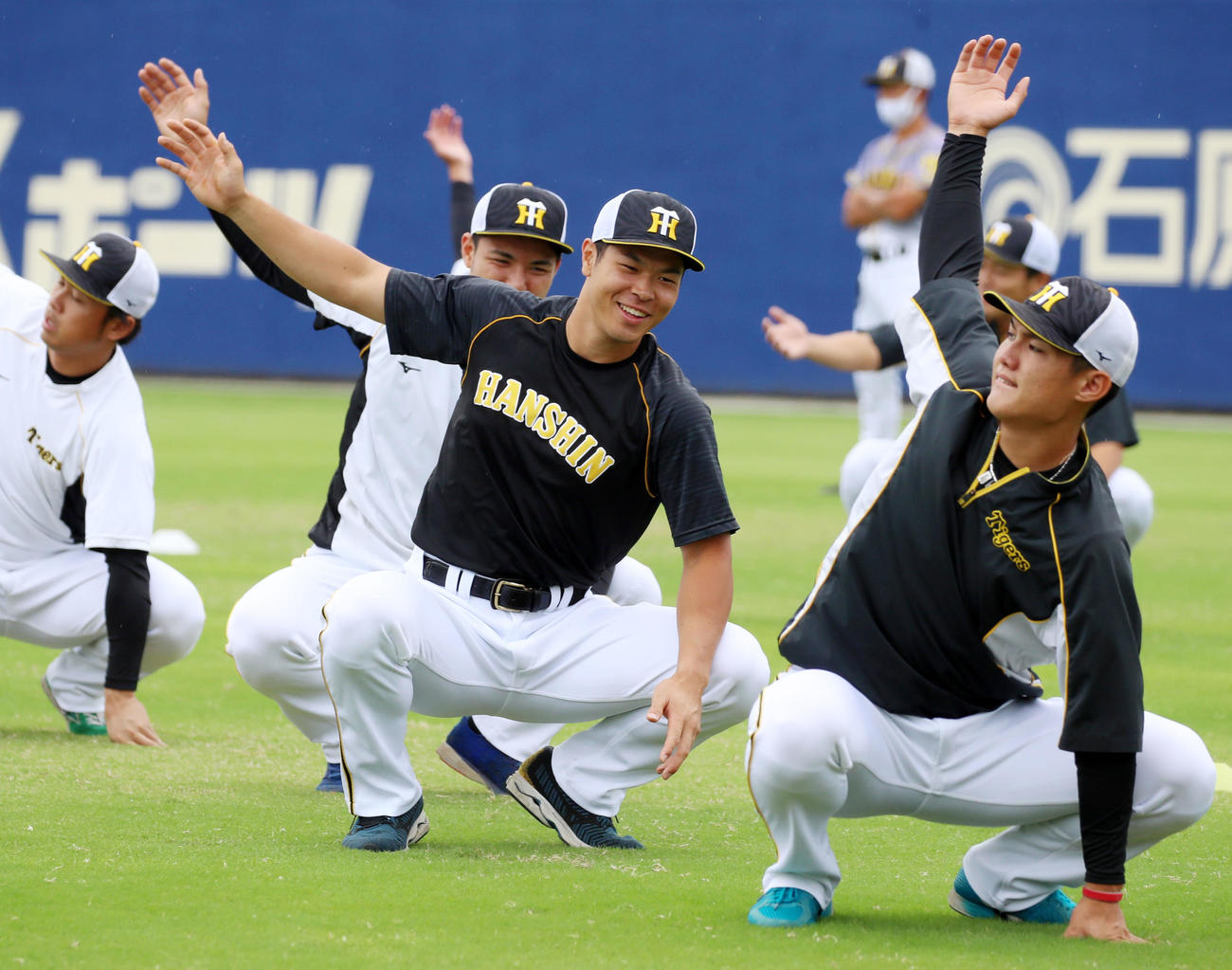 中日対阪神　明るい表情でウオーミングアップする佐藤輝。左は栄枝、右は西純（撮影・加藤哉）