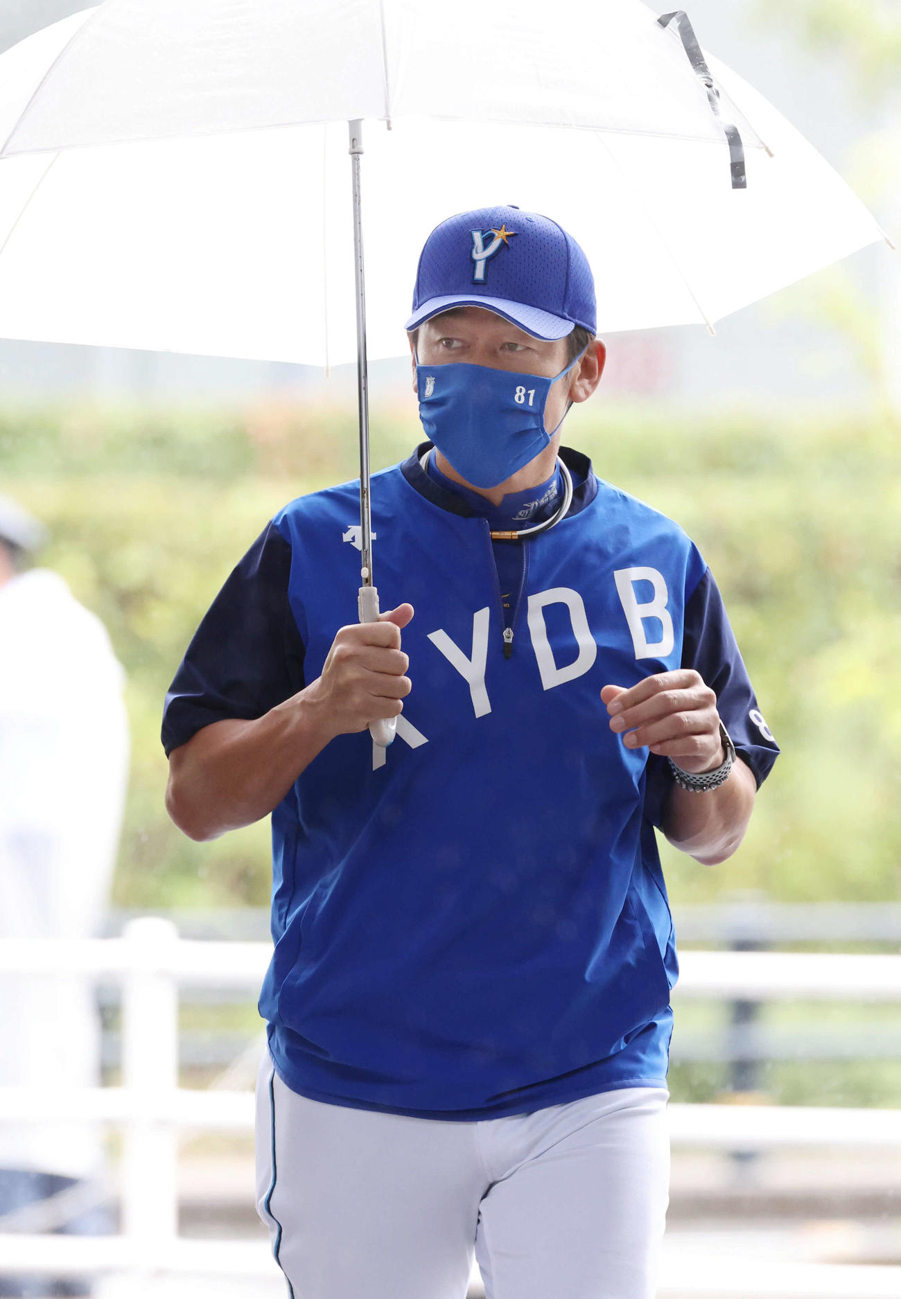 広島戦が雨天中止となり、傘を差して練習へ向かうDeNA三浦監督（撮影・加藤孝規）