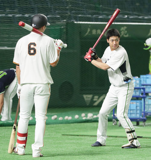 試合前、ヤクルト山田(右)の打撃練習を会話を交わしながら見つめる巨人坂本(撮影・足立雅史)