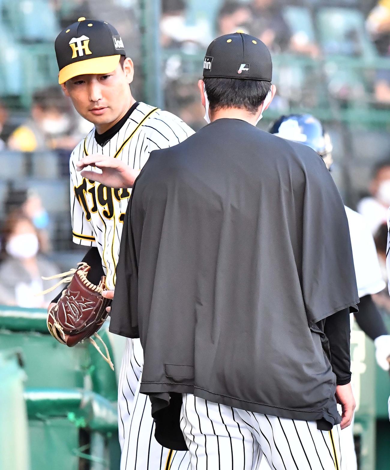阪神対中日　8回を無失点に抑た岩崎（左）は先発した高橋の肩を叩く（撮影・上田博志）