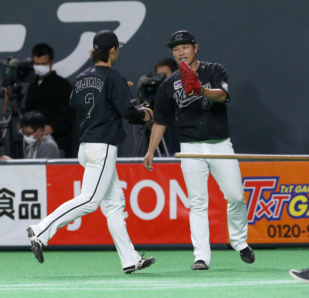 日本ハム対ロッテ　5回裏を無失点に抑えロッテ藤原（左手前）を出迎える岩下（撮影・佐藤翔太）