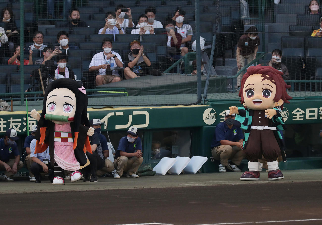 阪神対巨人　ファーストピッチセレモニーを行うパワプロくんの応援に駆けつけた鬼滅の刃の竈門炭治郎（右）と禰豆子（撮影・前田充）