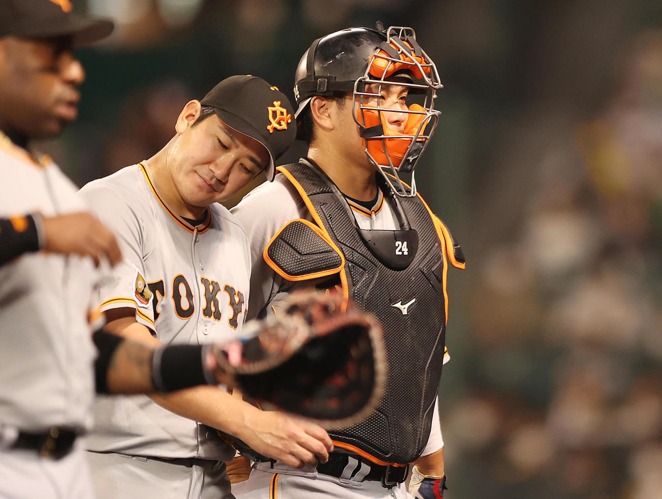 阪神対巨人　1回裏を終え、大城（右）と話しながら、首をかしげる菅野（撮影・狩俣裕三）