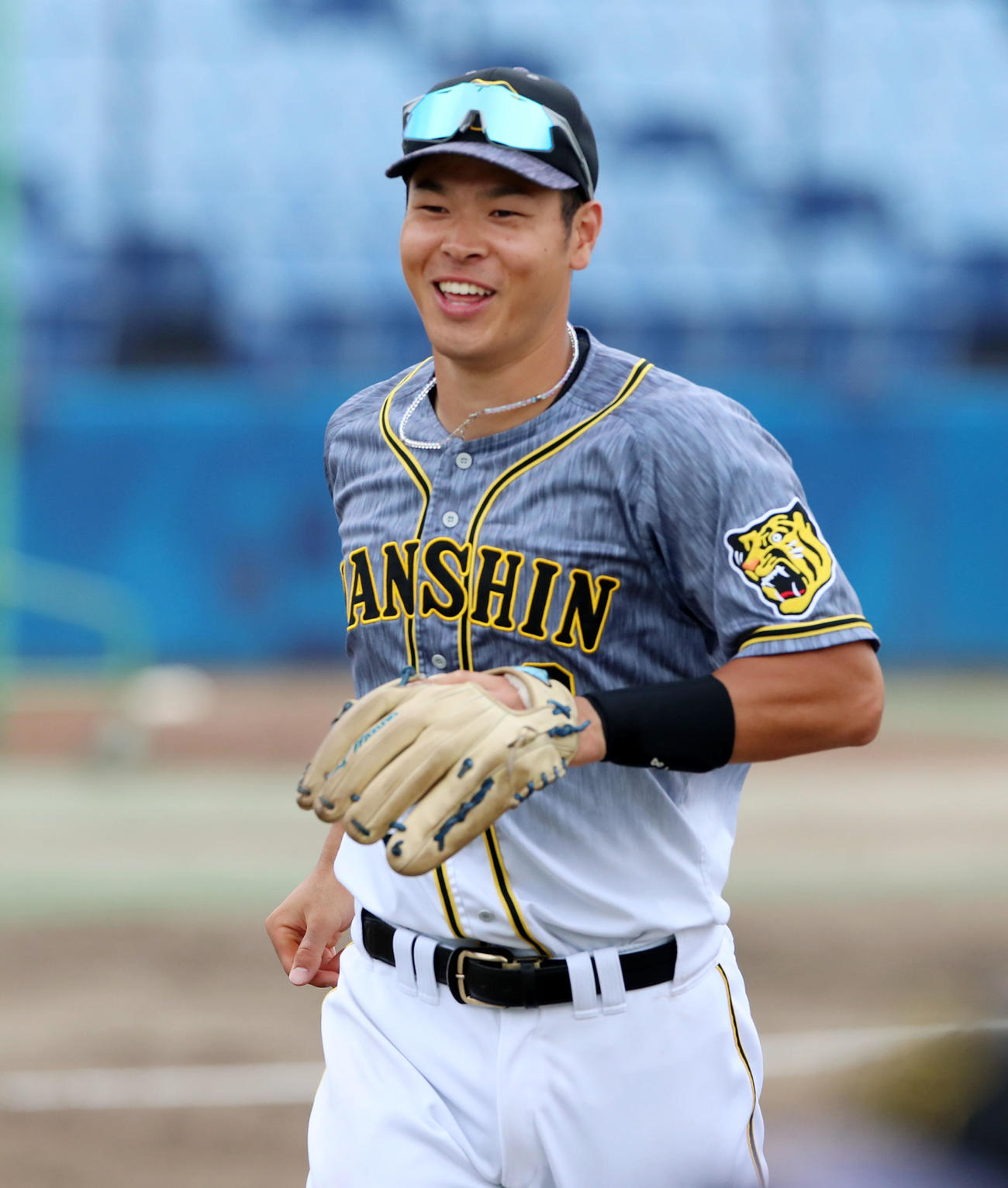 中日対阪神　8回裏から三塁守備に就いた佐藤輝は笑顔を見せてベンチへ戻る（撮影・加藤哉）