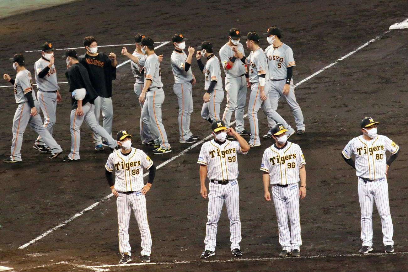 阪神対巨人　勝利を祝う巨人ナインを背にあいさつする阪神矢野監督（手前左）ら（撮影・上山淳一）