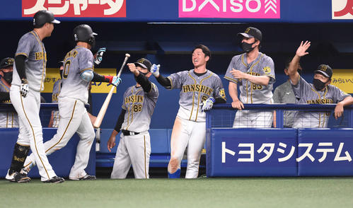中日対阪神　9回表阪神1死三塁、左犠飛を放った木浪を迎える矢野監督（左から3人目）ら（撮影・森本幸一）