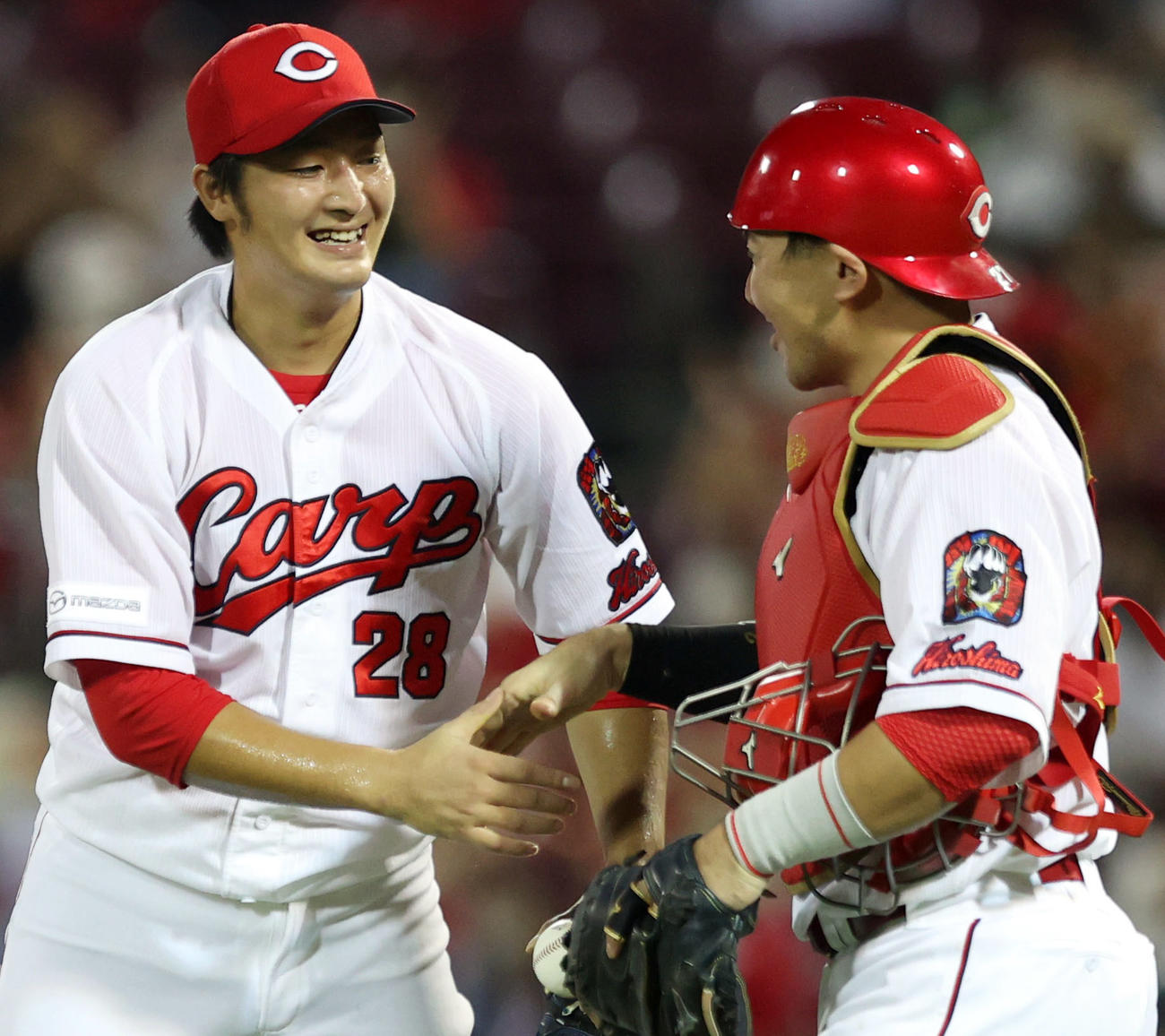 広島対巨人　プロ初完封勝利を挙げた床田（左）は、会沢と握手を交わす（撮影・狩俣裕三）