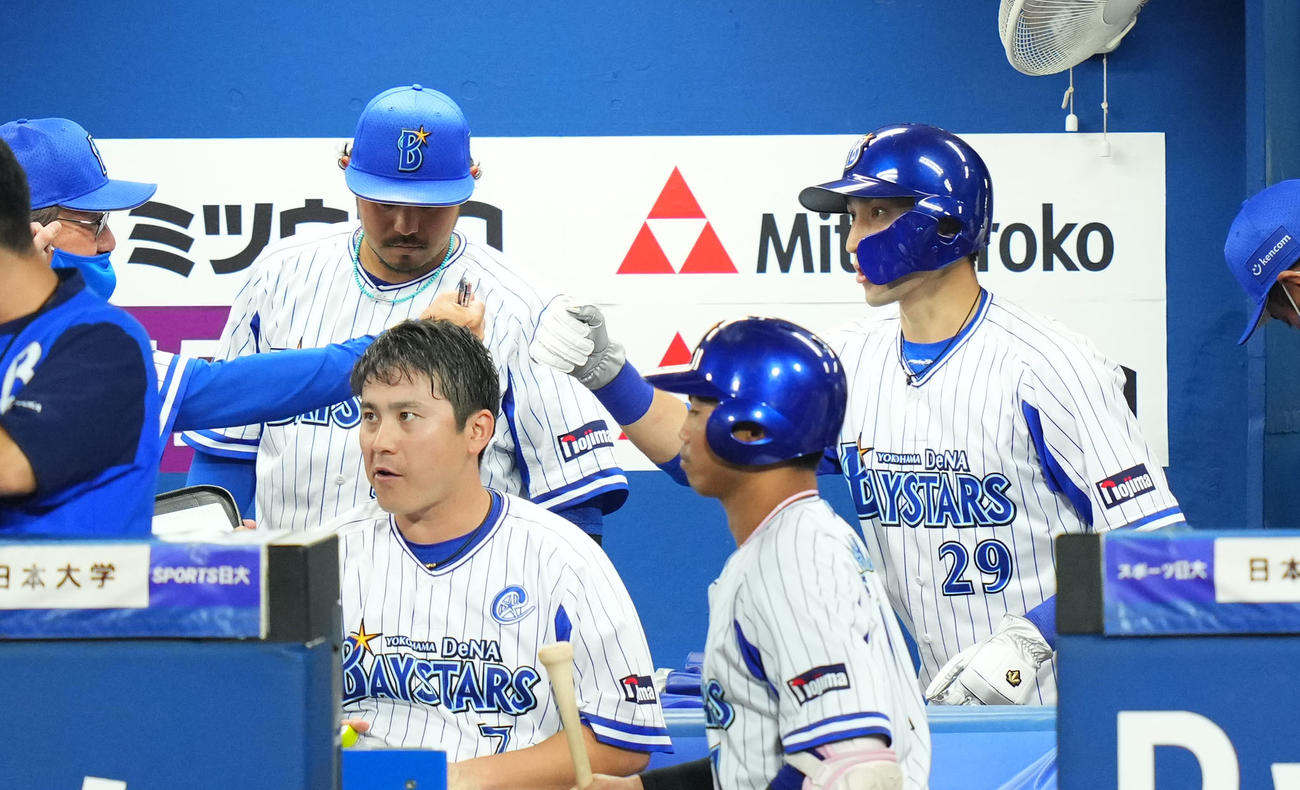 DeNA対ヤクルト　2回裏終了時、ベンチでナインとタッチを交わすDeNA伊藤光（右）（撮影・横山健太）