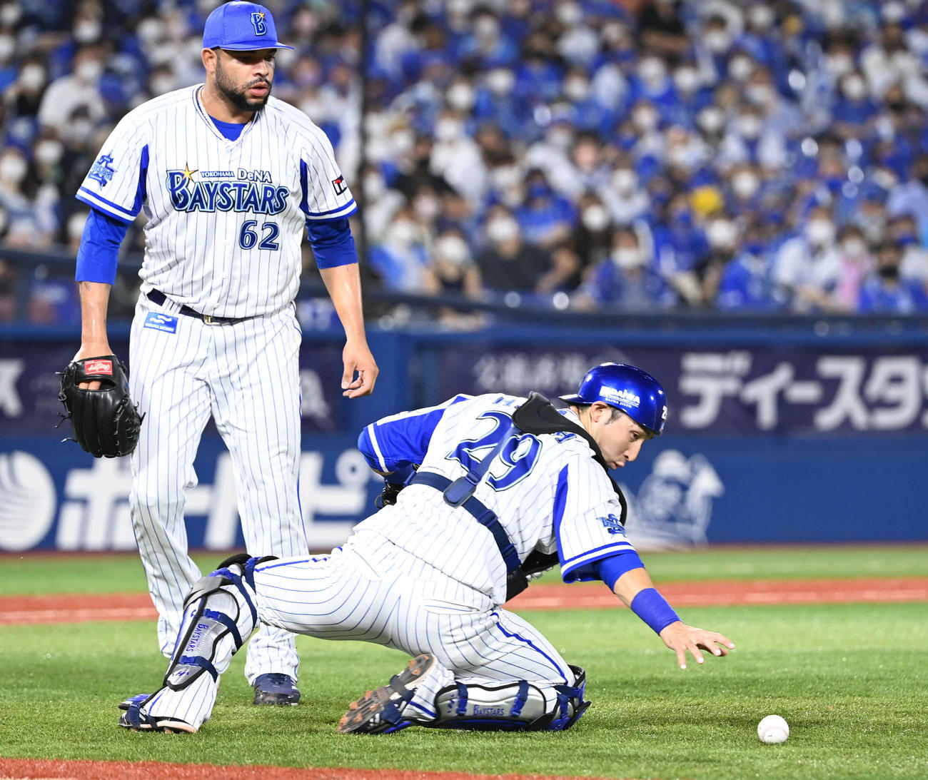 DeNA対ヤクルト　9回表ヤクルト1死一塁、西浦のバント安打の打球処理に手間取るエスコバー（左）と捕手伊藤光（撮影・山崎安昭）