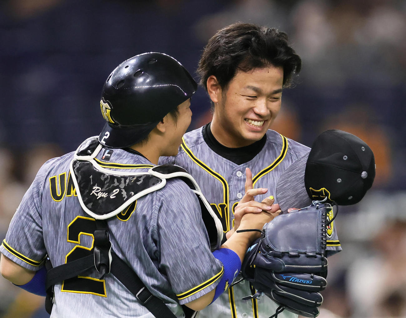 プロ初完封勝利を飾った阪神高橋（右）は梅野と笑顔でタッチを交わす（撮影・足立雅史）