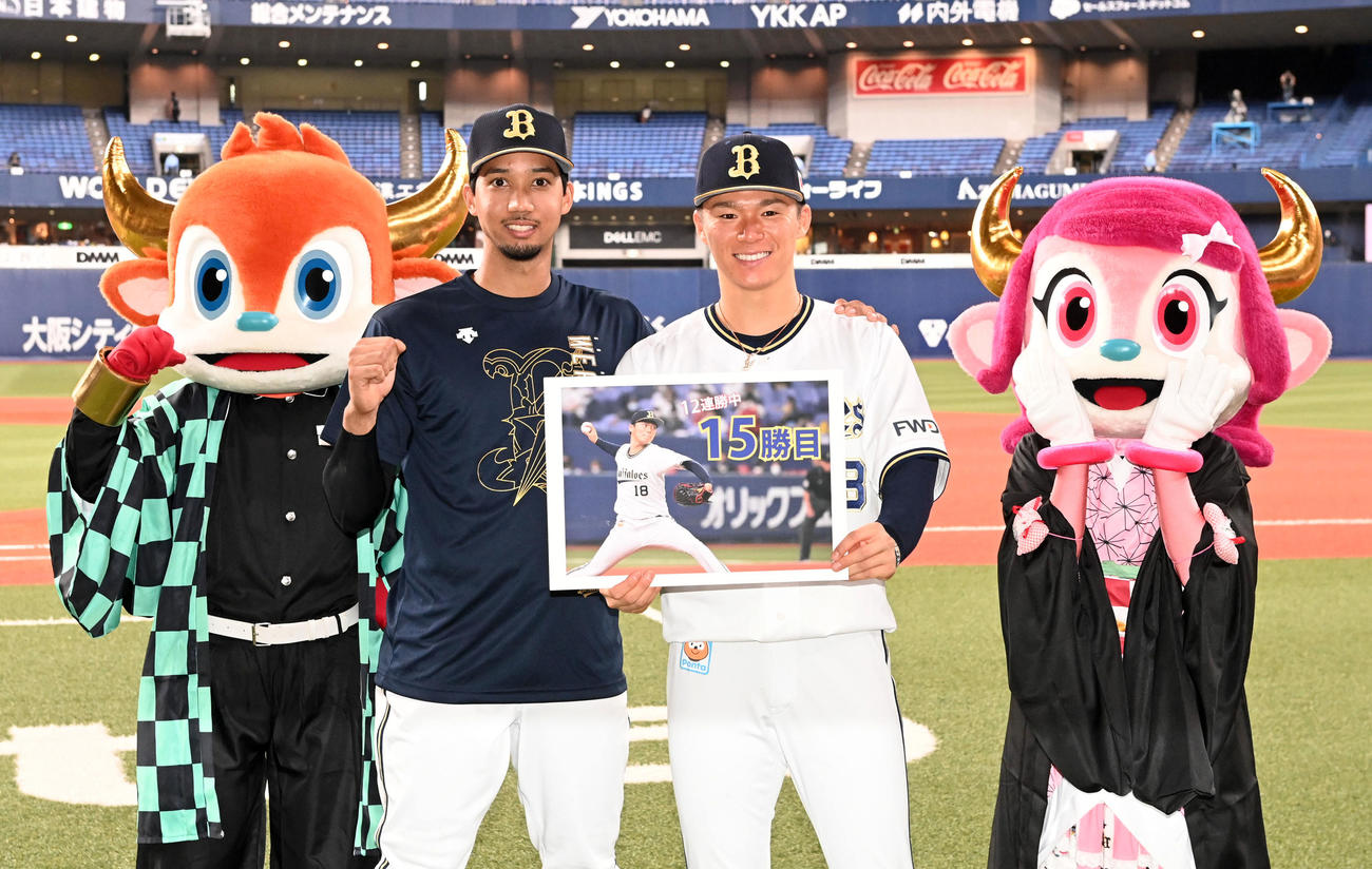 オリックス対楽天　15勝目の山本（右）は記念ボードを手に宗の祝福に笑顔を見せる（撮影・前岡正明）