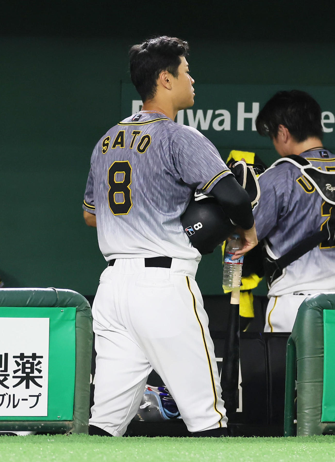 巨人対阪神　8回表阪神無死、中飛に倒れた佐藤輝はこの回で交代となり荷物を手に引き揚げる（撮影・足立雅史）