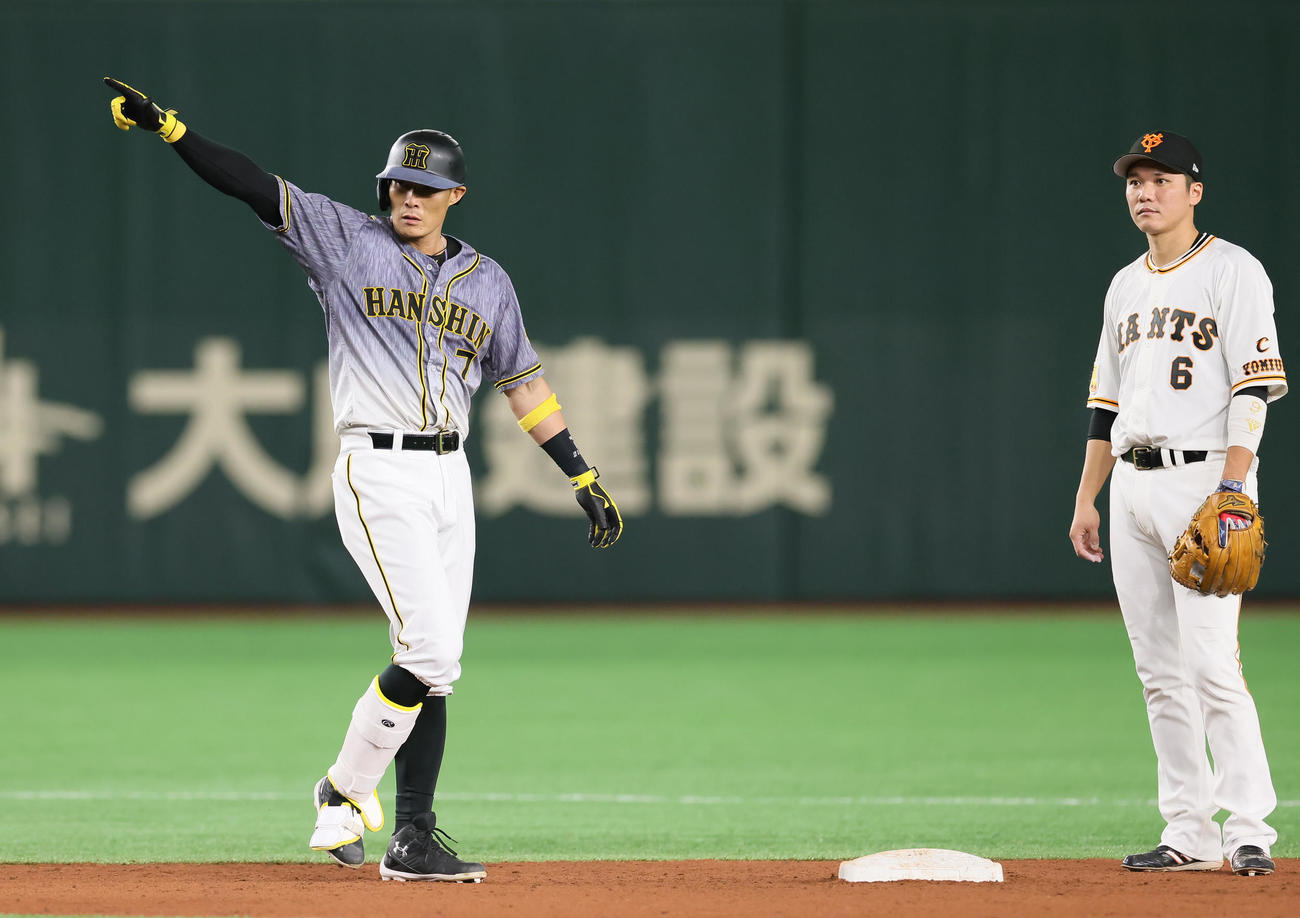 巨人対阪神　5回表阪神2死満塁、走者一掃の適時二塁打を放ちベンチを指さす糸井（左）。右は巨人坂本（撮影・足立雅史）