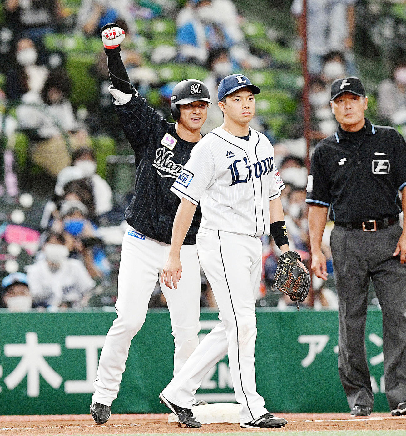 西武対ロッテ7回表ロッテ1死満塁、藤岡（左）は右翼線に走者一掃の適時三塁打を放ちベンチへガッツポーズする。右は呉（撮影・滝沢徹郎）