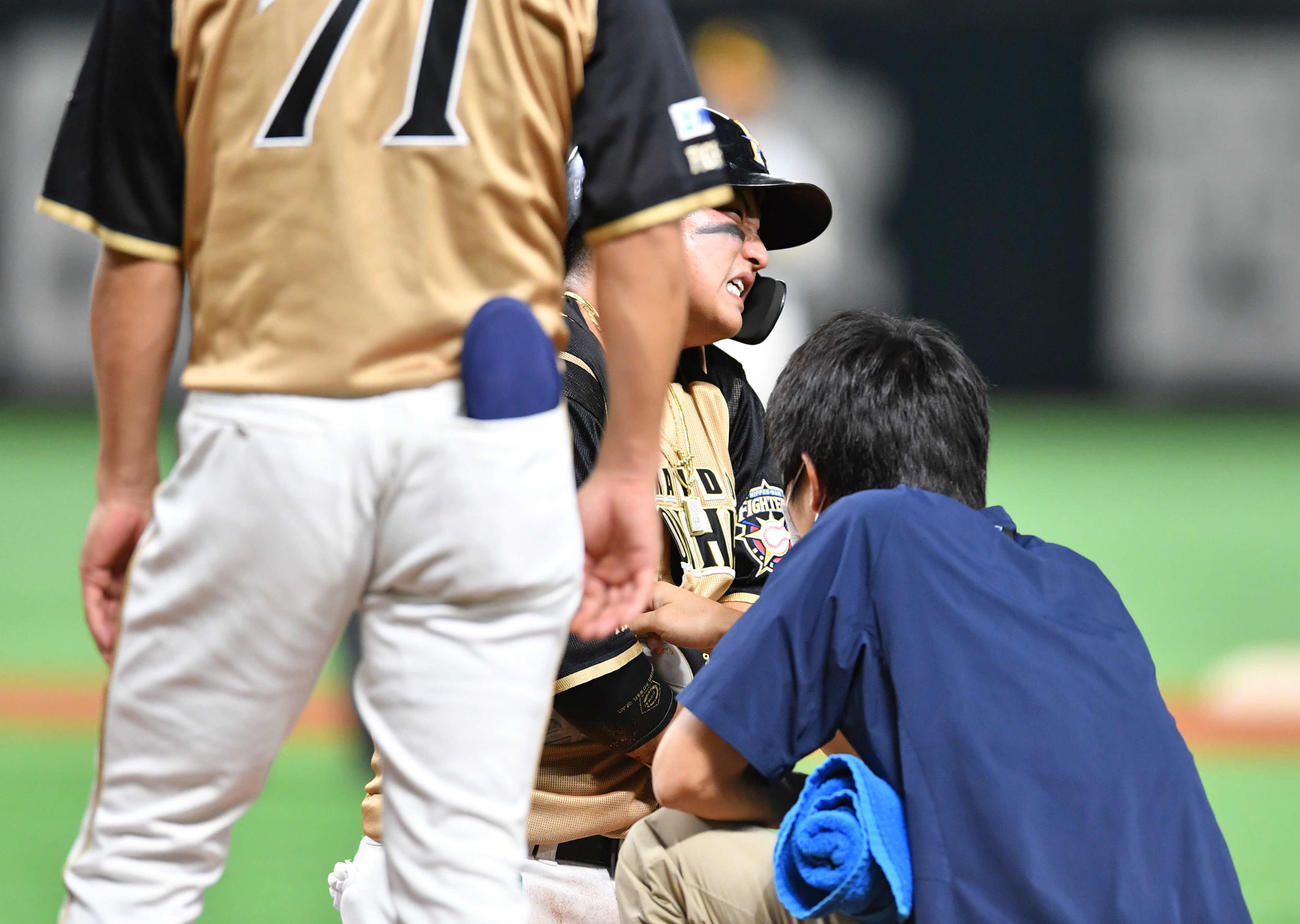 ソフトバンク対日本ハム　7回表日本ハム1死一塁、けん制で帰塁した時に手を痛め、顔をゆがめる佐藤（撮影・岩下翔太）