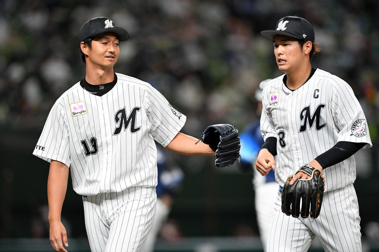 ロッテ唐川（左）は中村奨とタッチを交わす（21年9月25日撮影）