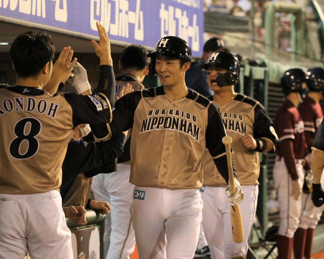 楽天対日本ハム　5回表日本ハム1死二塁、2点本塁打を放ちナインに出迎えられる石井（撮影・黒川智章）