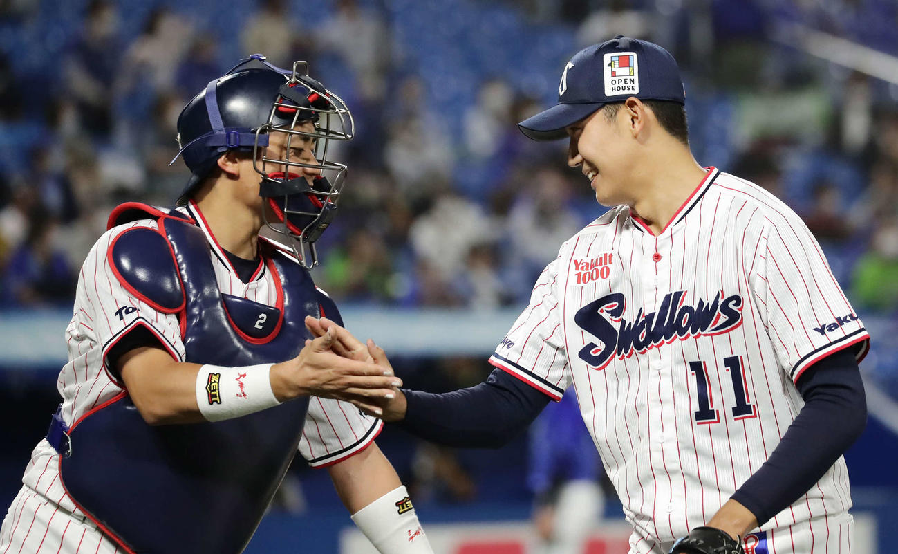ヤクルト対DeNA 3回表DeNA2死三塁、佐野を空振り三振に仕留めて捕手中村とタッチする奥川（撮影・丹羽敏通）
