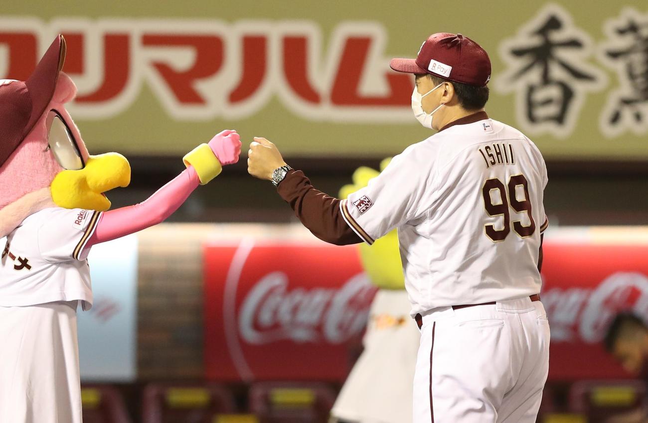楽天対日本ハム　試合後、腕時計をした左腕でマスコットとタッチする石井GM兼監督（撮影・黒川智章）