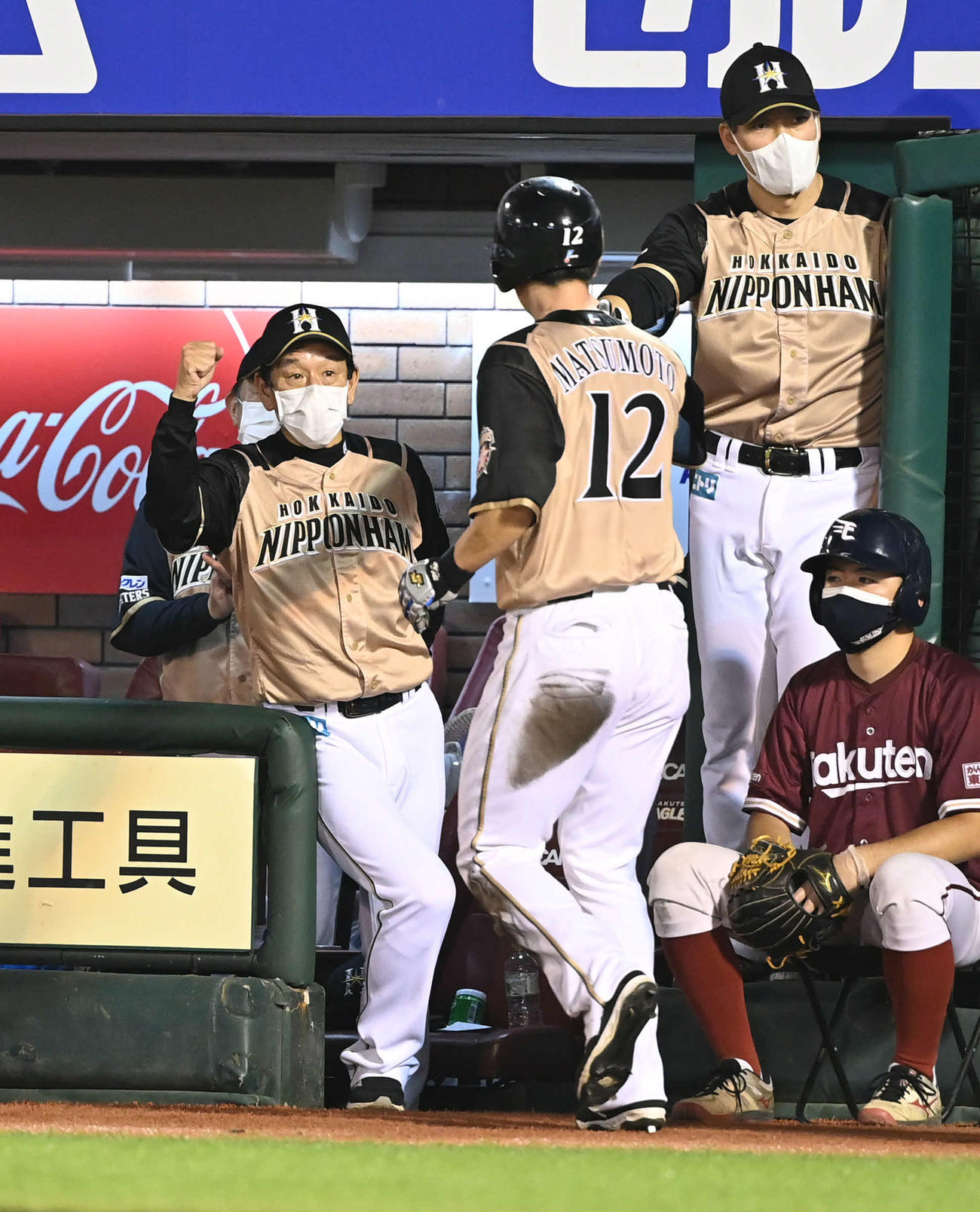 楽天対日本ハム　8回表日本ハム1死二、三塁、栗山監督（左）は野村の2点適時打で生還した松本剛（左から2人目）とエアタッチ（撮影・山崎安昭）