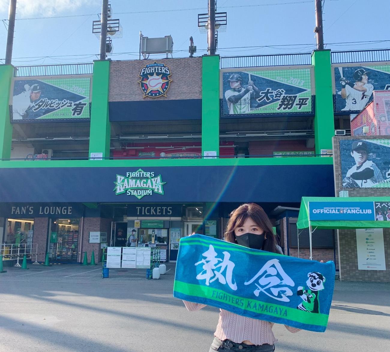 スタジアム前で「執念」タオルを持つ宮崎美穂