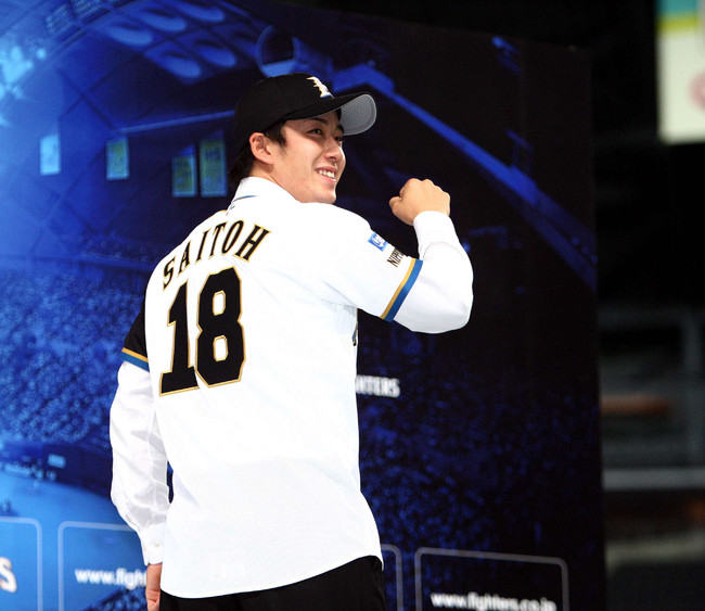 10年12月9日、入団発表で日本ハム背番号18のユニホームに袖を通しポーズをとる斎藤佑樹