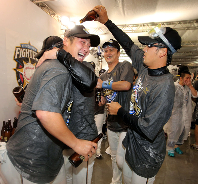 12年10月2日　優勝ビール掛け　日本ハム中田翔（左）へビールを掛ける斎藤佑樹。中央は金子誠