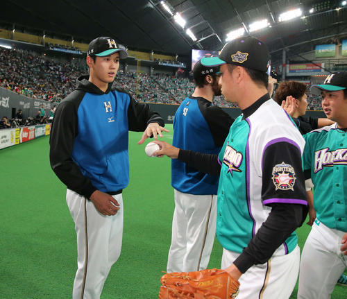 16年5月22日 日本ハム対楽天 今季2勝目を挙げた大谷翔平投手(左)は最後を締めた斎藤佑樹投手(右)からウイニングボールを受け取る