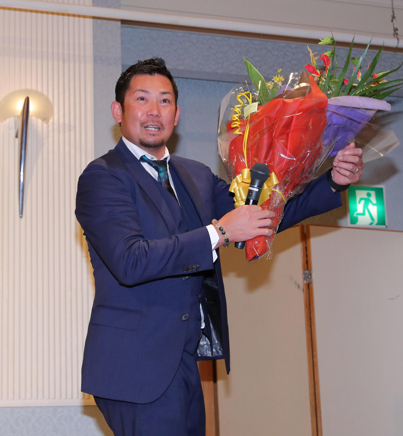 現役引退の記者会見を終えた岩田は花束を手に会場を後にする
