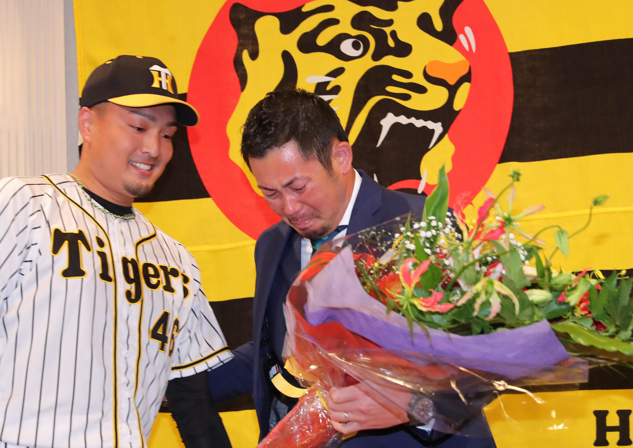 秋山（左）がサプライズで登場し、岩田に花束を渡す