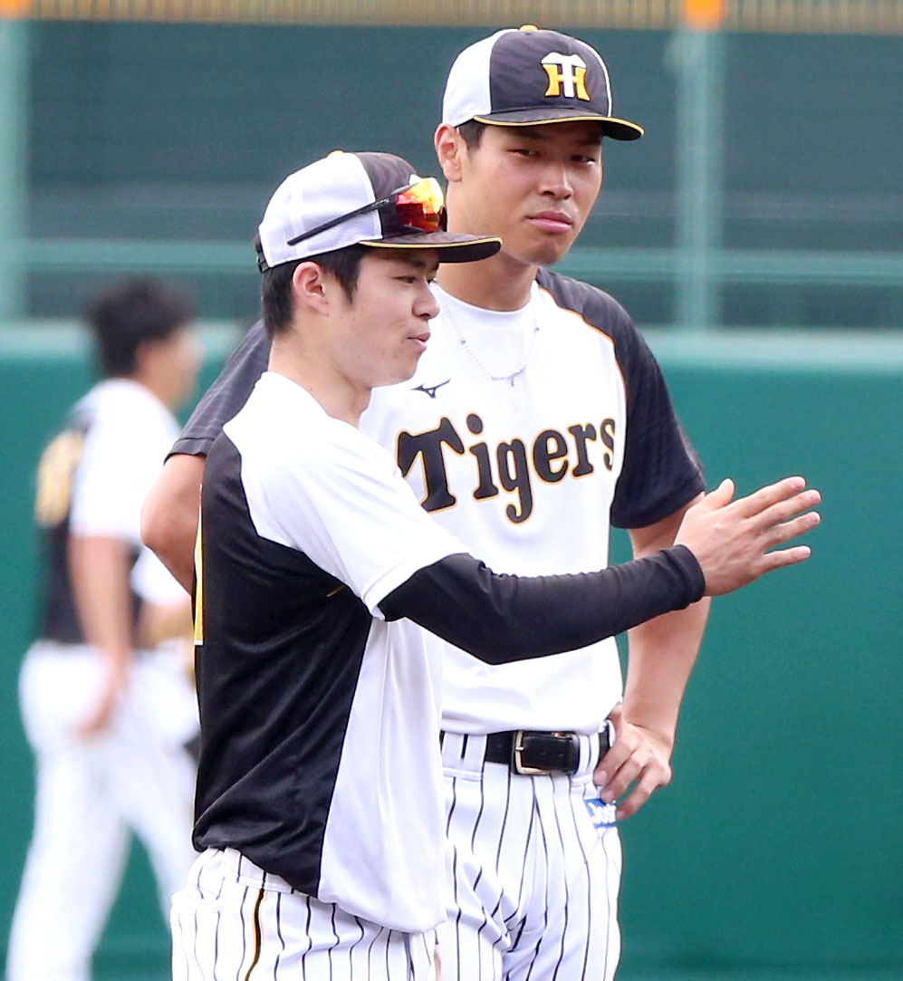 阪神対中日　試合前の練習で、中野（手前）と話す佐藤輝（撮影・上山淳一）