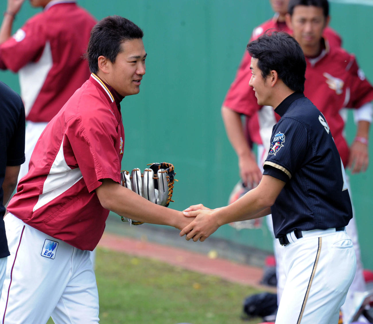 11年2月、楽天田中将（左）と再会して両手で握手を交わす日本ハム斎藤