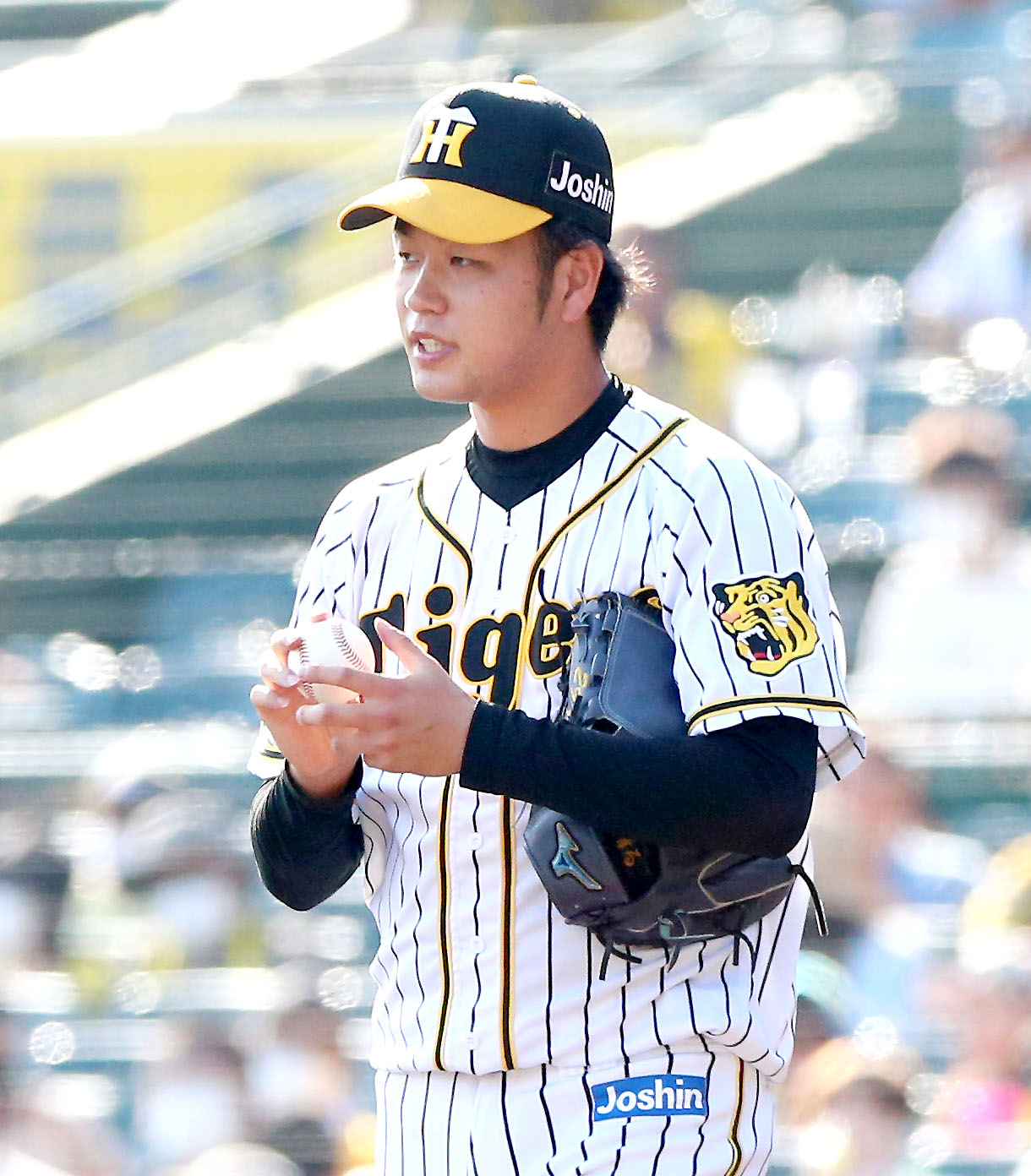 阪神対中日　5回、好投の阪神高橋は笑顔でボールをさわる（撮影・上山淳一）