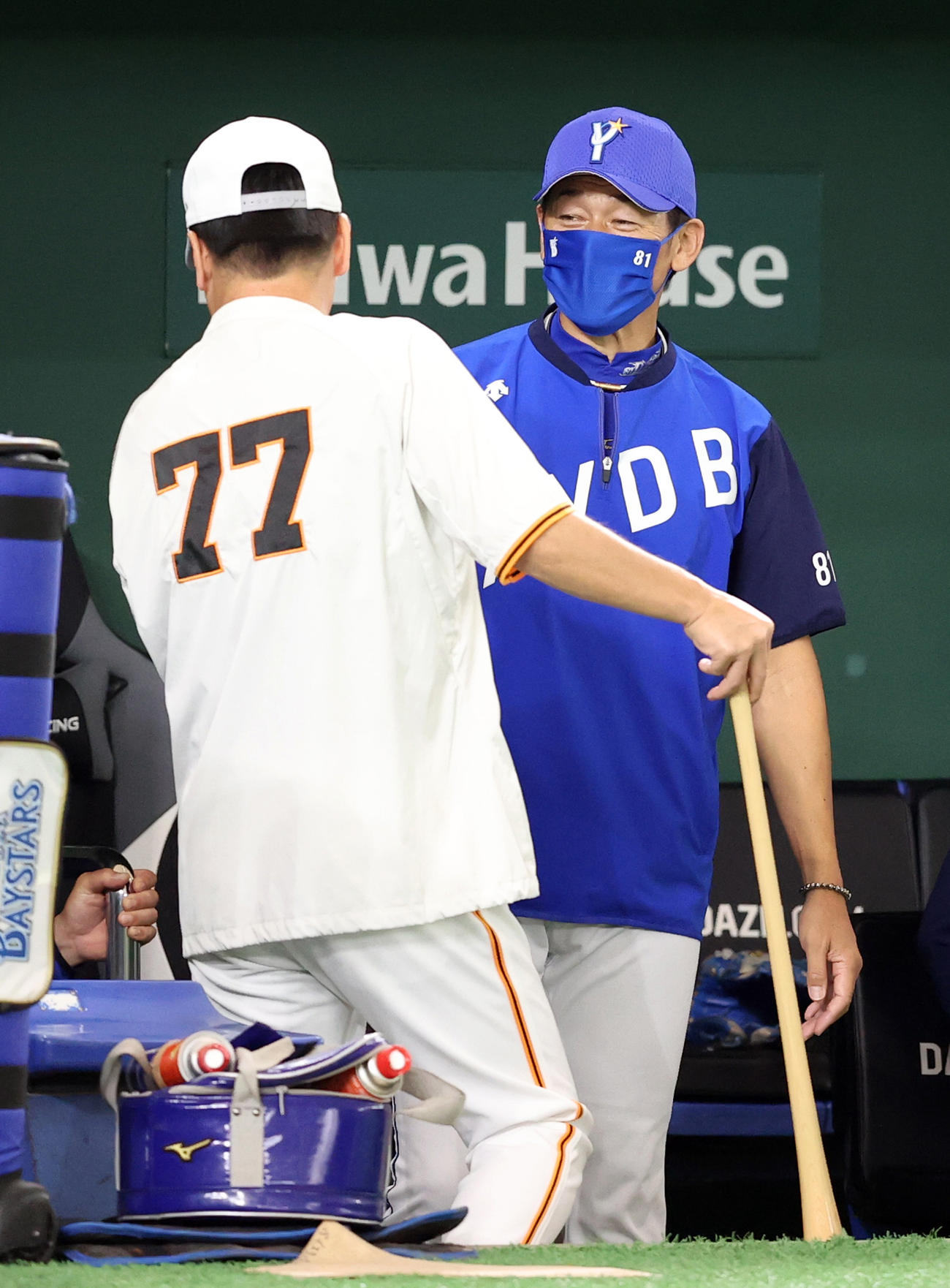 巨人対DeNA　試合前の練習で、元木ヘッドコーチ（左）から何らかの報告を受ける三浦監督（撮影・狩俣裕三）