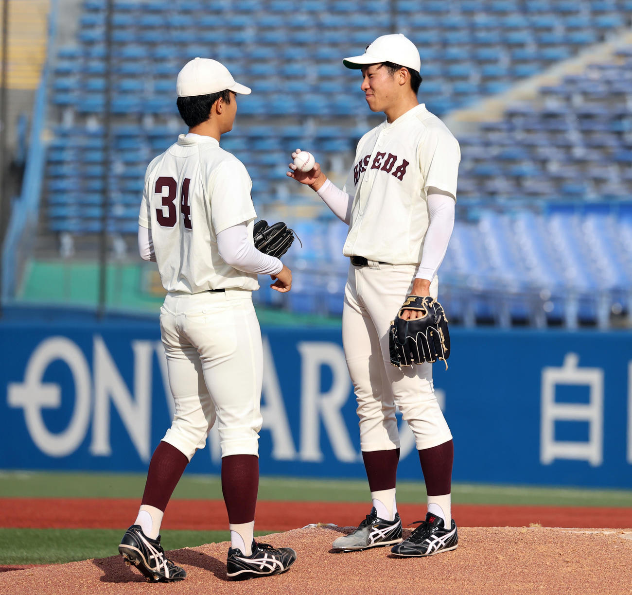 早大対東大　7回裏東大1死三塁、足がつって降板となった早大徳山（右）は、初登板となったユエンにボールを渡す（撮影・浅見桂子）