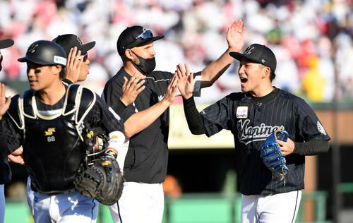 楽天対ロッテ　完封勝ちしナインとタッチを交わすロッテ小島（右）（撮影・滝沢徹郎）